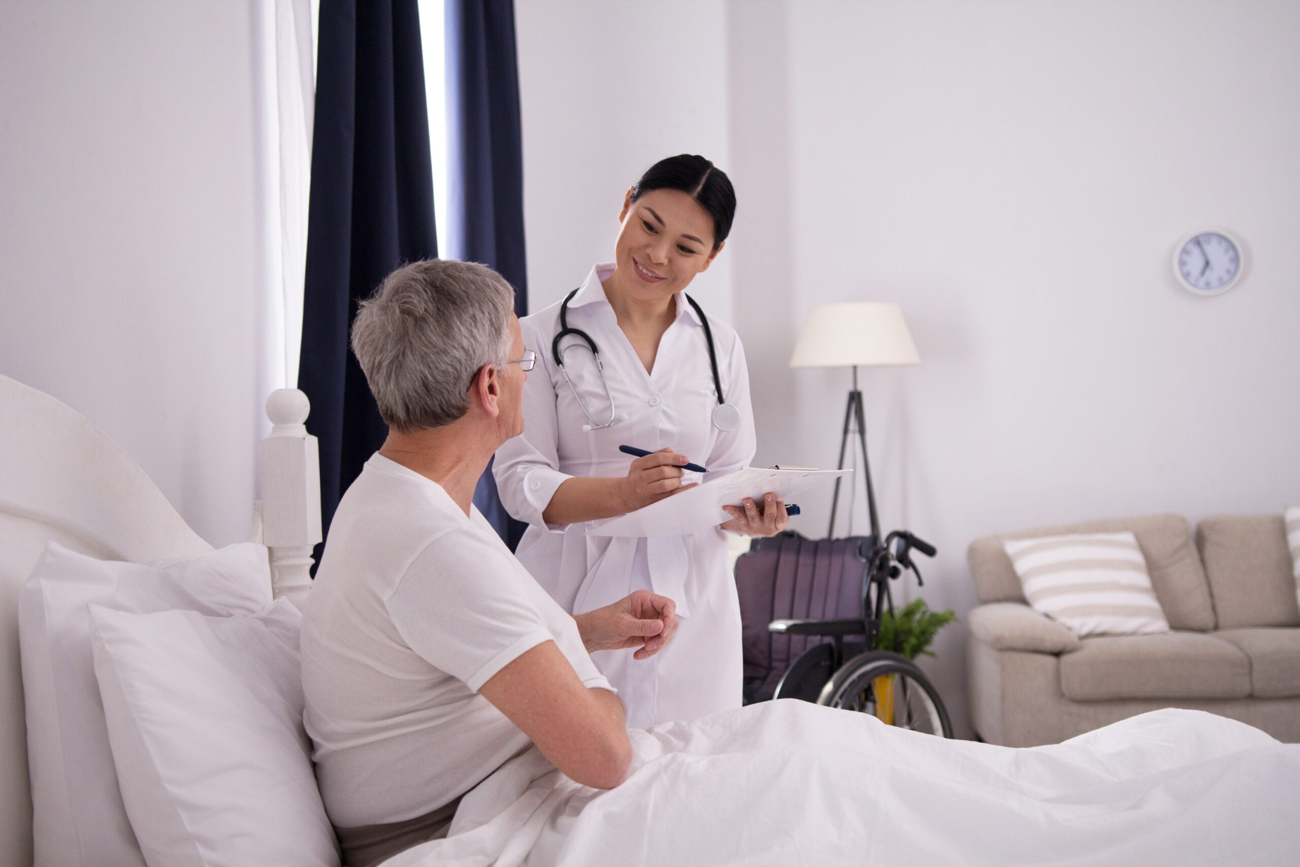 A healthcare provider discussing medication options with an elderly male patient in a home setting, focusing on prior authorization requirements for Temazepam with Caremark.