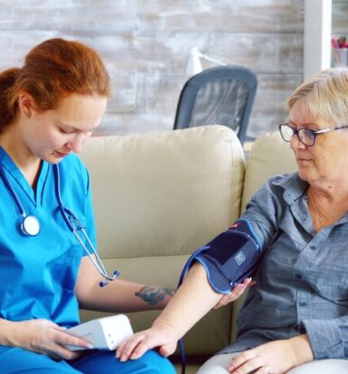 Nurse checking blood pressure of an elderly patient, discussing prior authorization for Novolog insulin treatment.