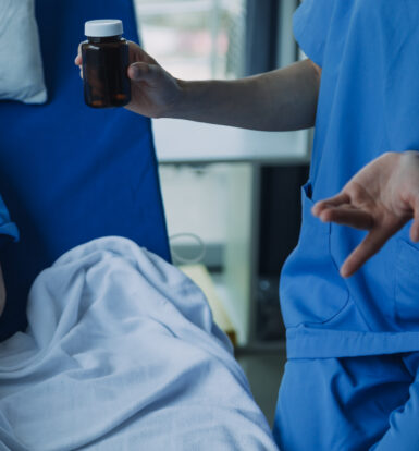 Healthcare provider holding a medication bottle while discussing Temazepam use for insomnia management with a patient.