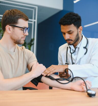 Doctor measuring a patient's blood pressure, illustrating the need for effective hypertension management with medications like Amlodipine Olmesartan.