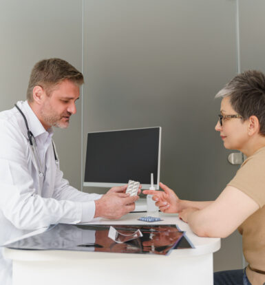 Doctor discussing medication options with a patient for managing GERD symptoms and the Medicare prior authorization requirements for Pantoprazole Sodium packets.