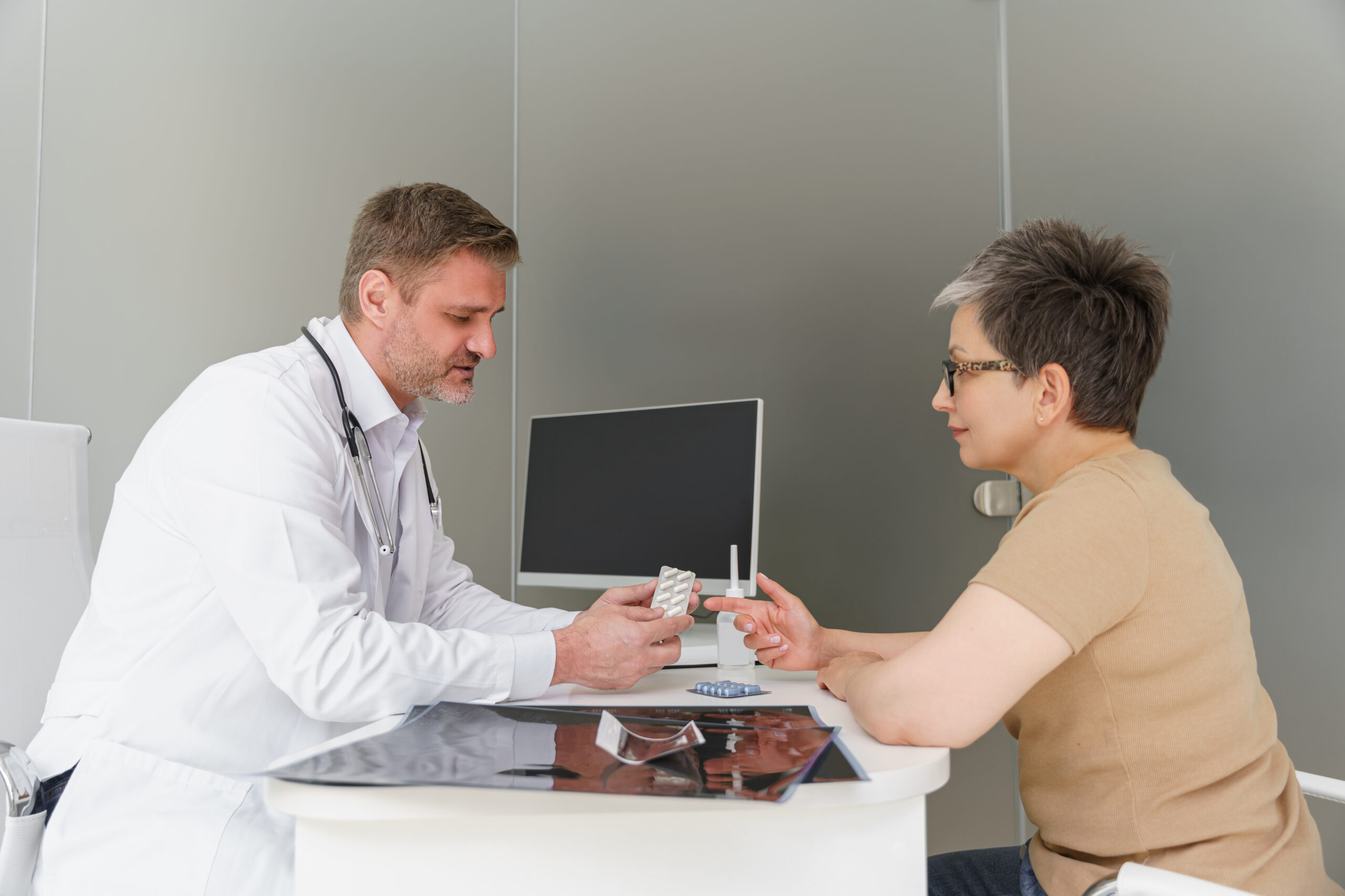 Doctor discussing medication options with a patient for managing GERD symptoms and the Medicare prior authorization requirements for Pantoprazole Sodium packets.