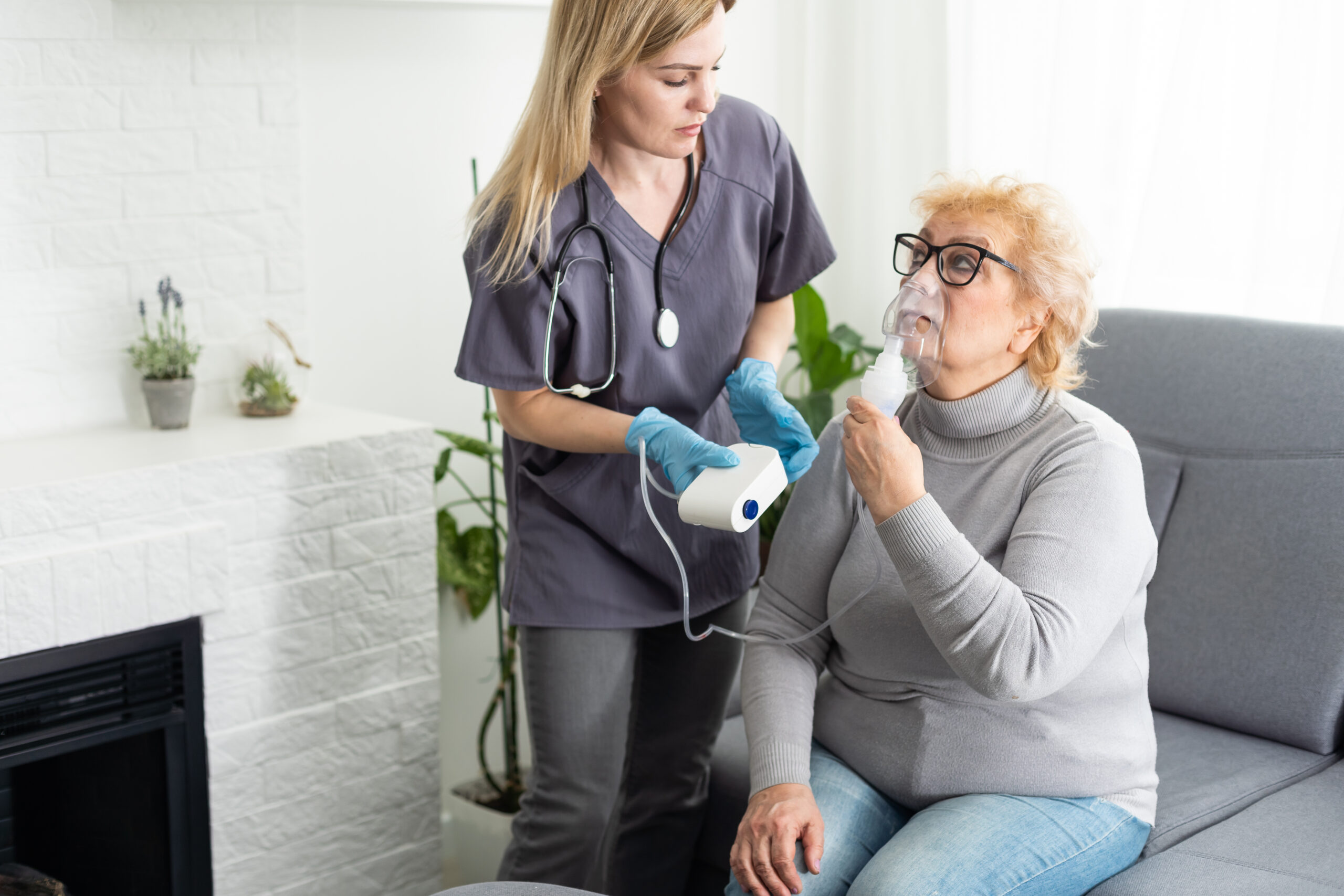 Nurse assisting an elderly patient with a nebulizer for respiratory treatment, highlighting the importance of prior authorization for respiratory medications like Air Suppress Aerosol.