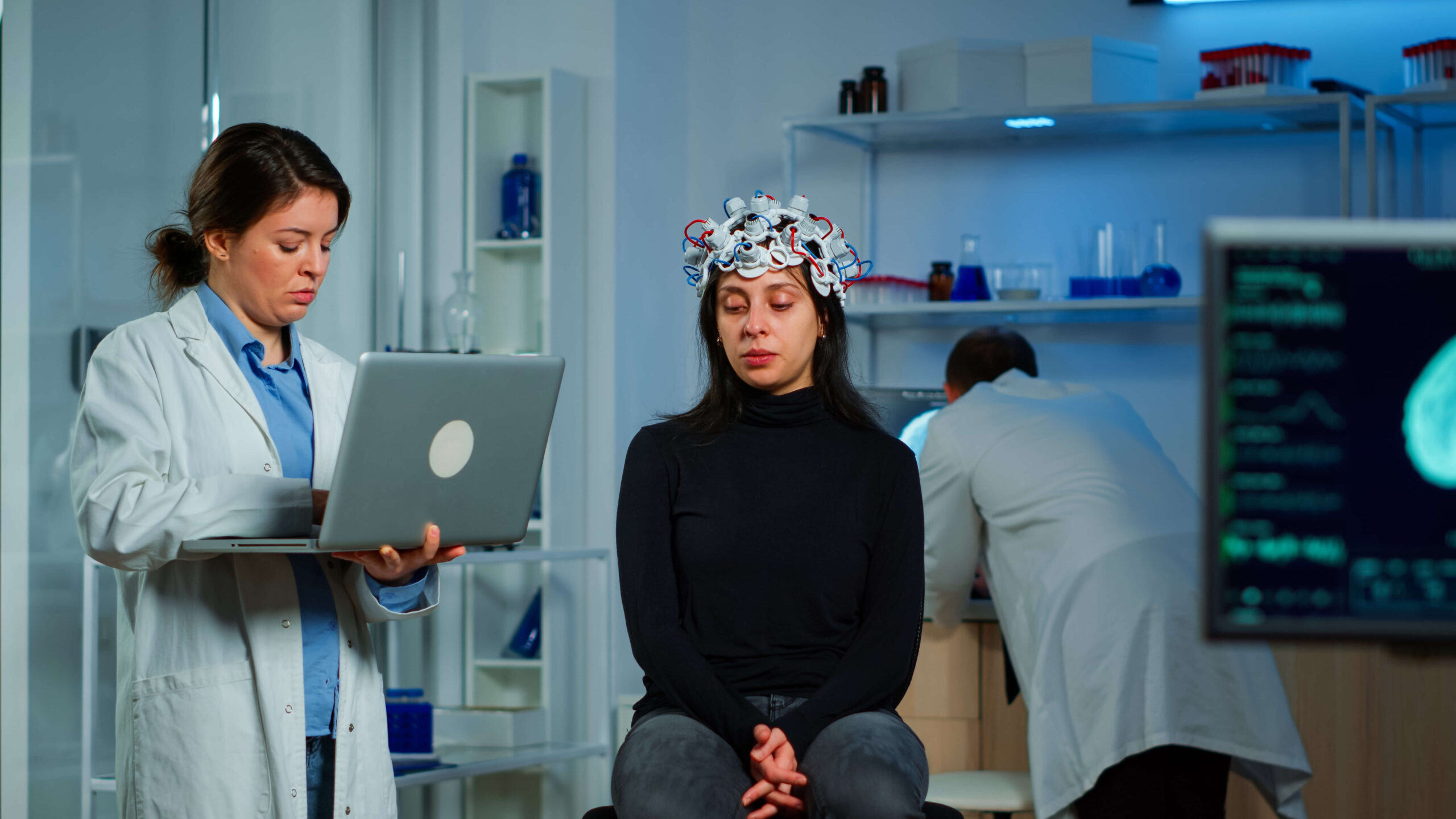 Healthcare professional conducting a mental health evaluation using advanced monitoring equipment in a clinical setting.