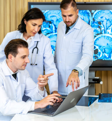 Healthcare providers reviewing patient documentation on a laptop for prior authorization of OxyContin ER