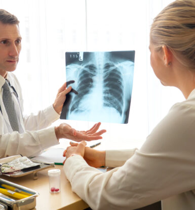 A healthcare provider showing a patient a chest X-ray image during a discussion about COPD treatment options and the necessity for prior authorization of Razor Powder with Sunshine Health Plan.