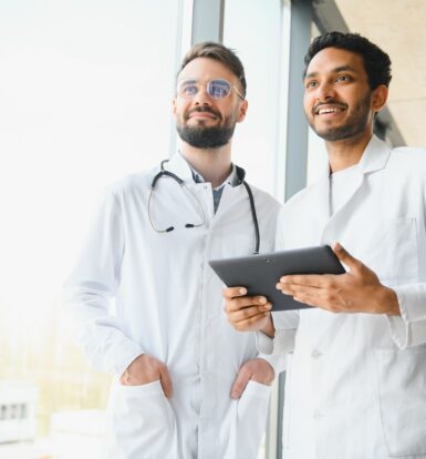 Two doctors discussing patient information on a tablet for Sunshine Health Medicaid prior authorization of the Ford Drone YMGN 100 Unit for diabetes management.