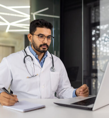 Doctor reviewing patient records on a laptop for Medicare prior authorization of Submittedin for GERD treatment.