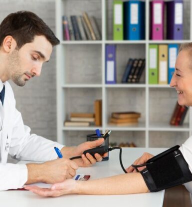 Doctor taking patient’s blood pressure while discussing prior authorization for Insulin Lispro with Optum.