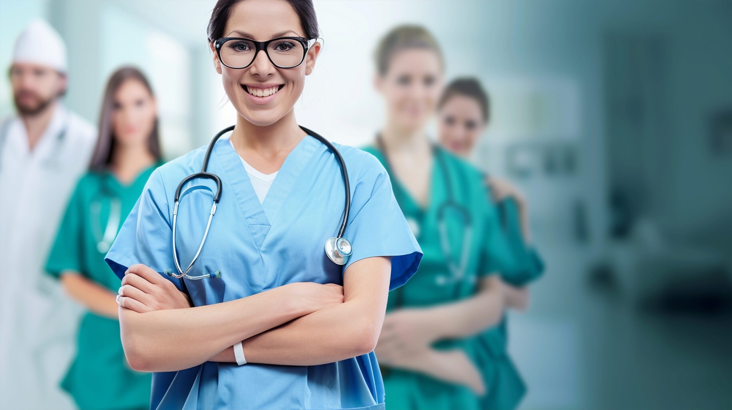 Smiling nurse in blue scrubs with a stethoscope, standing confidently in front of a team of healthcare professionals, symbolizing teamwork in LTC.