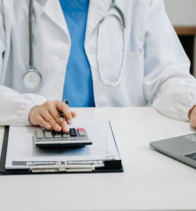 A medical coder reviewing documents on a computer screen.