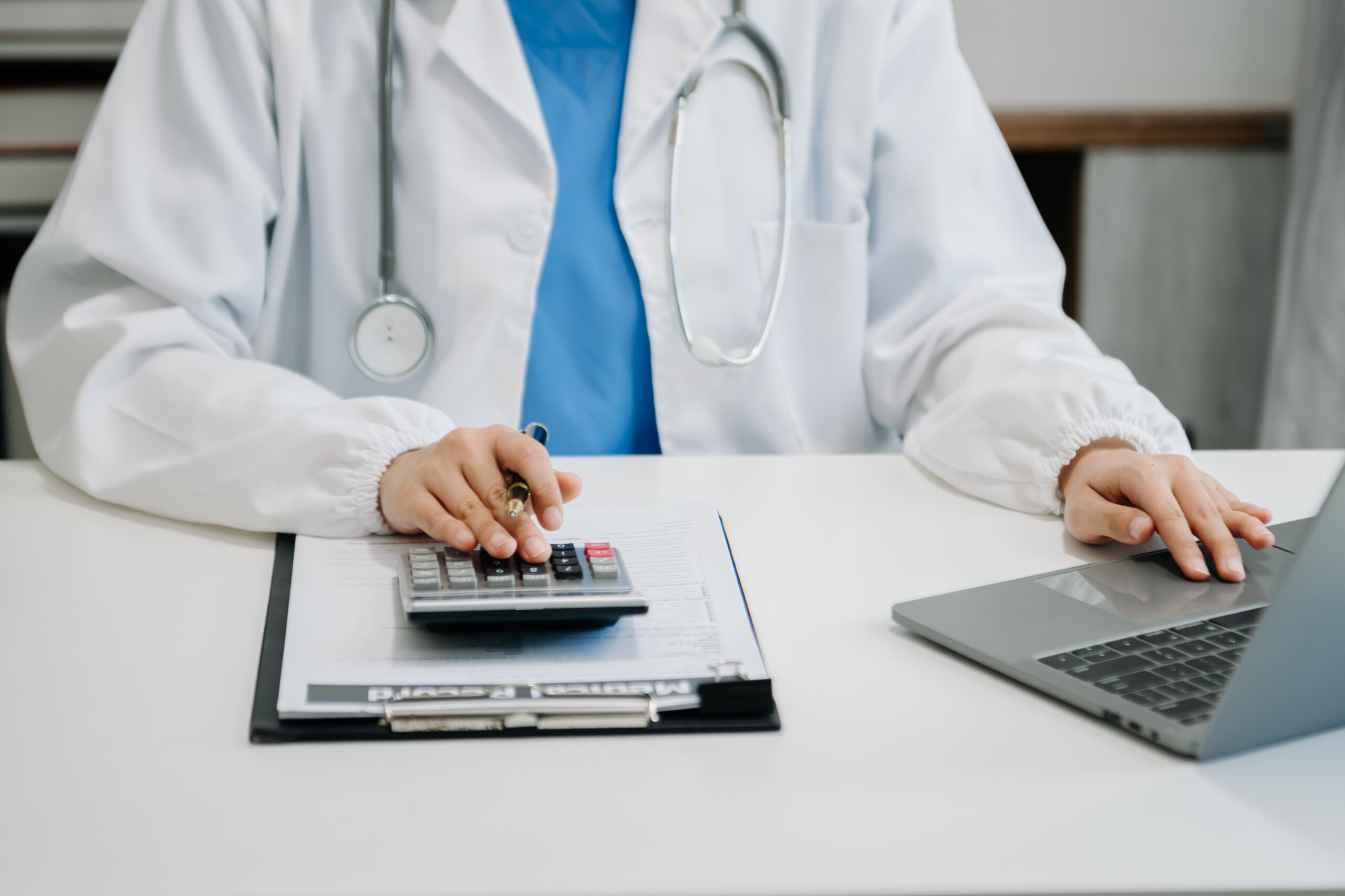 A medical coder reviewing documents on a computer screen.