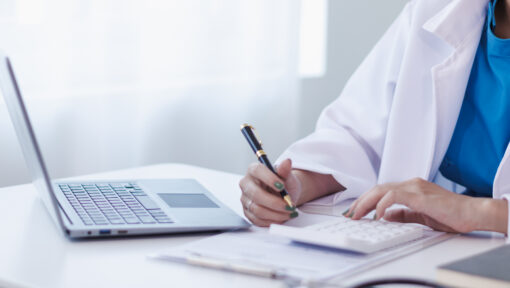 A medical scribe and coder working together in a healthcare setting.