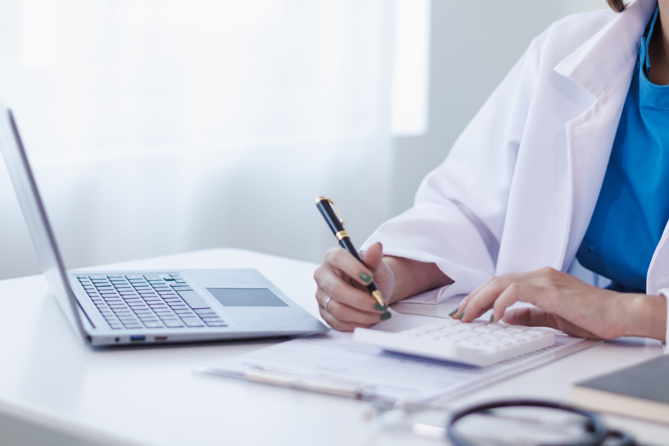 A medical scribe and coder working together in a healthcare setting.