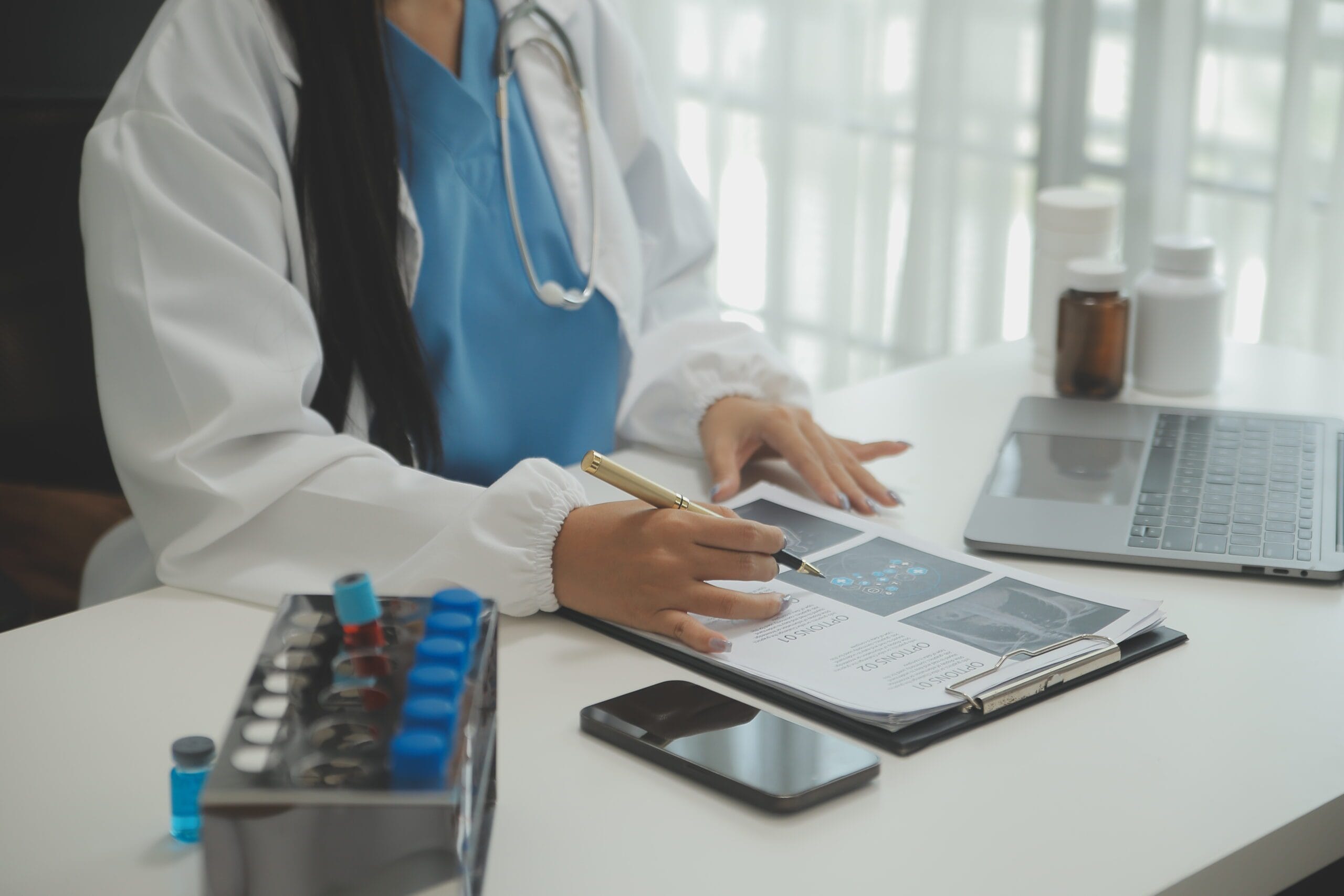 A medical scribe documenting a telemedicine consultation on a laptop.