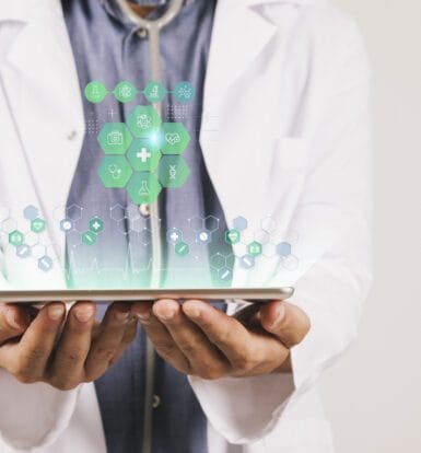 Healthcare provider holding a tablet displaying virtual medical icons, symbolizing digital medical coding and healthcare technology.