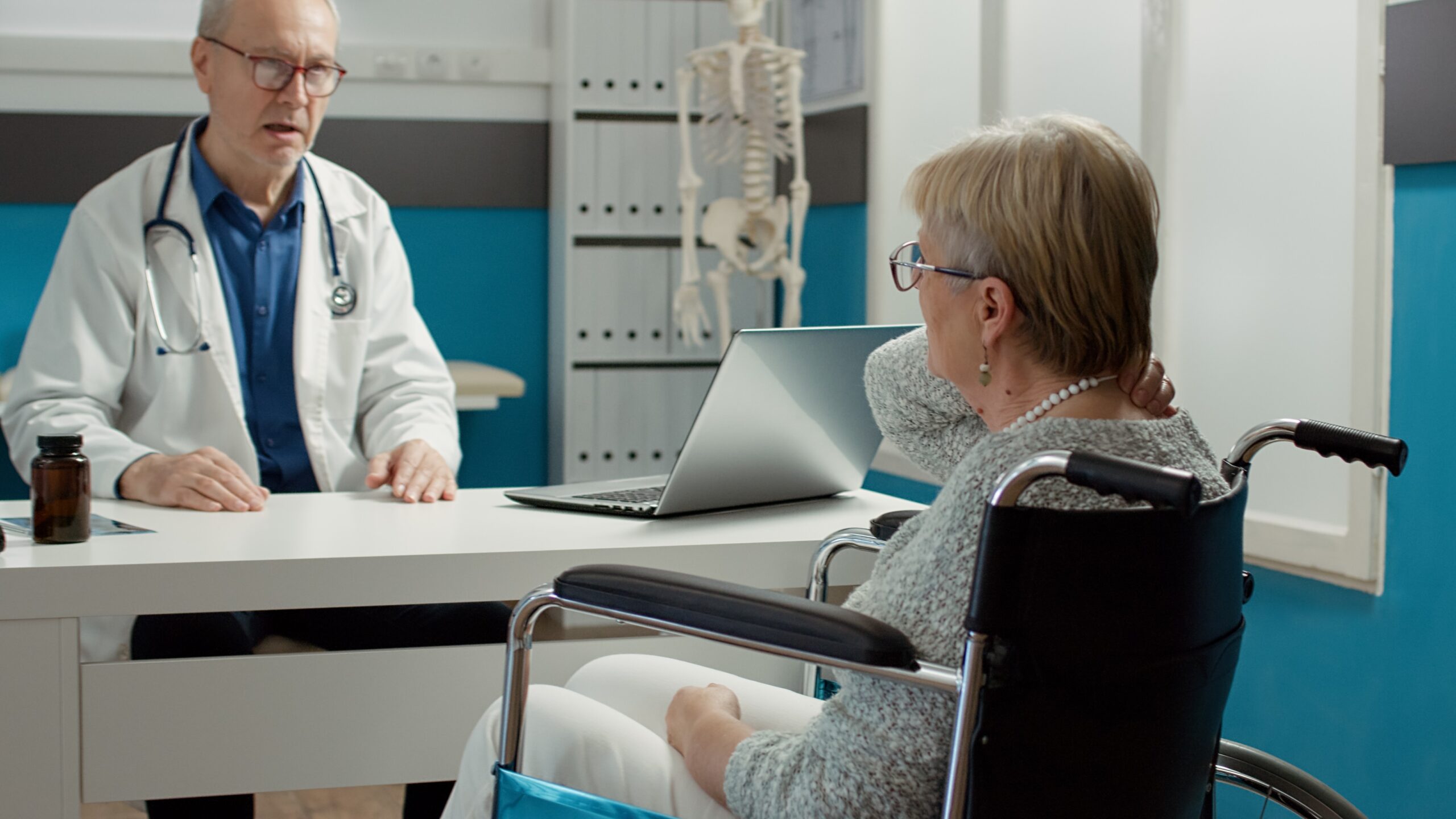 Doctor consulting a patient in a wheelchair about prior authorization for medication