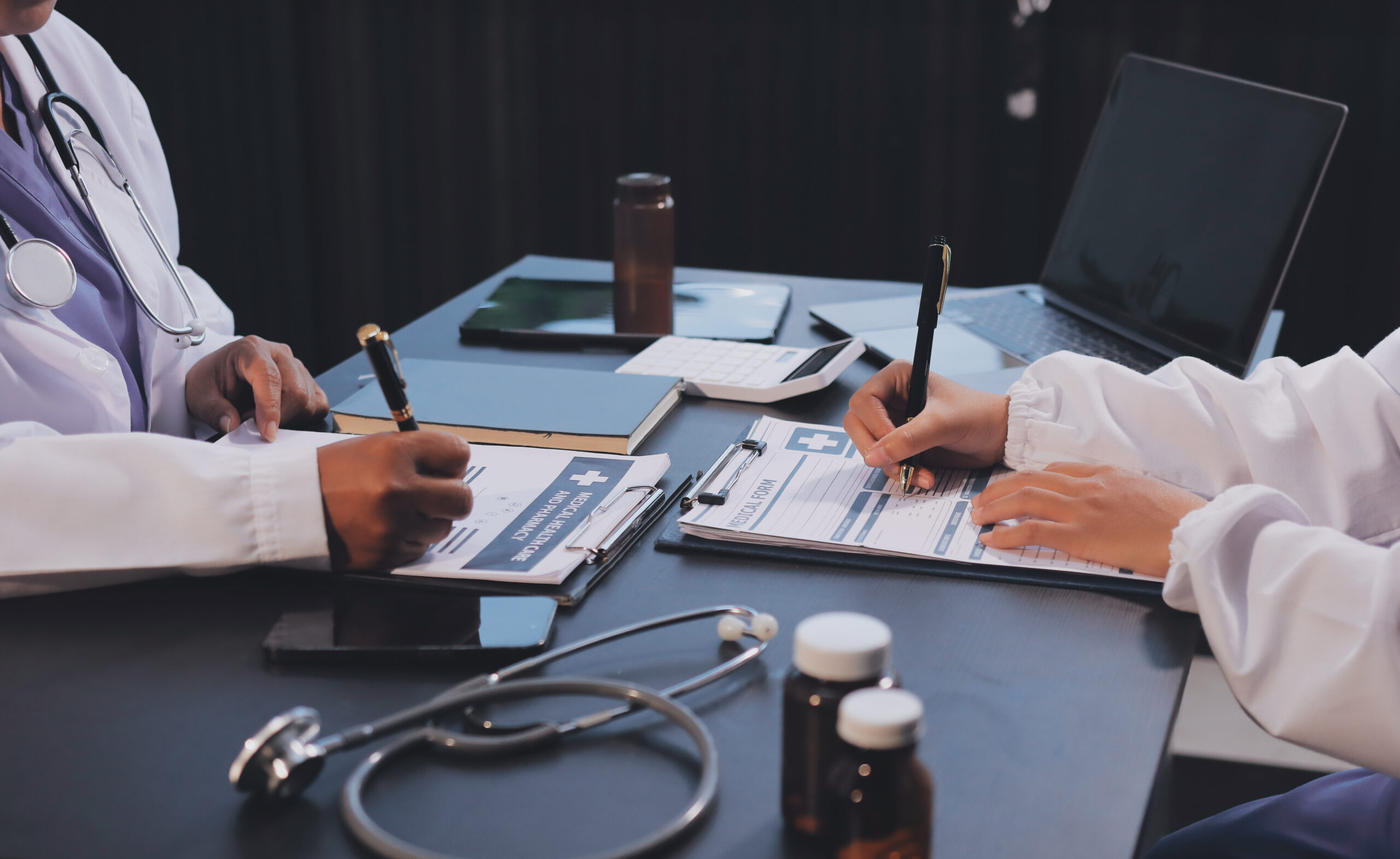 A healthcare administrator reviewing a patient’s insurance details on a computer, checking for coverage and prior authorization requirements.