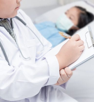 A pediatric endocrinologist reviewing medical records with a coding specialist.