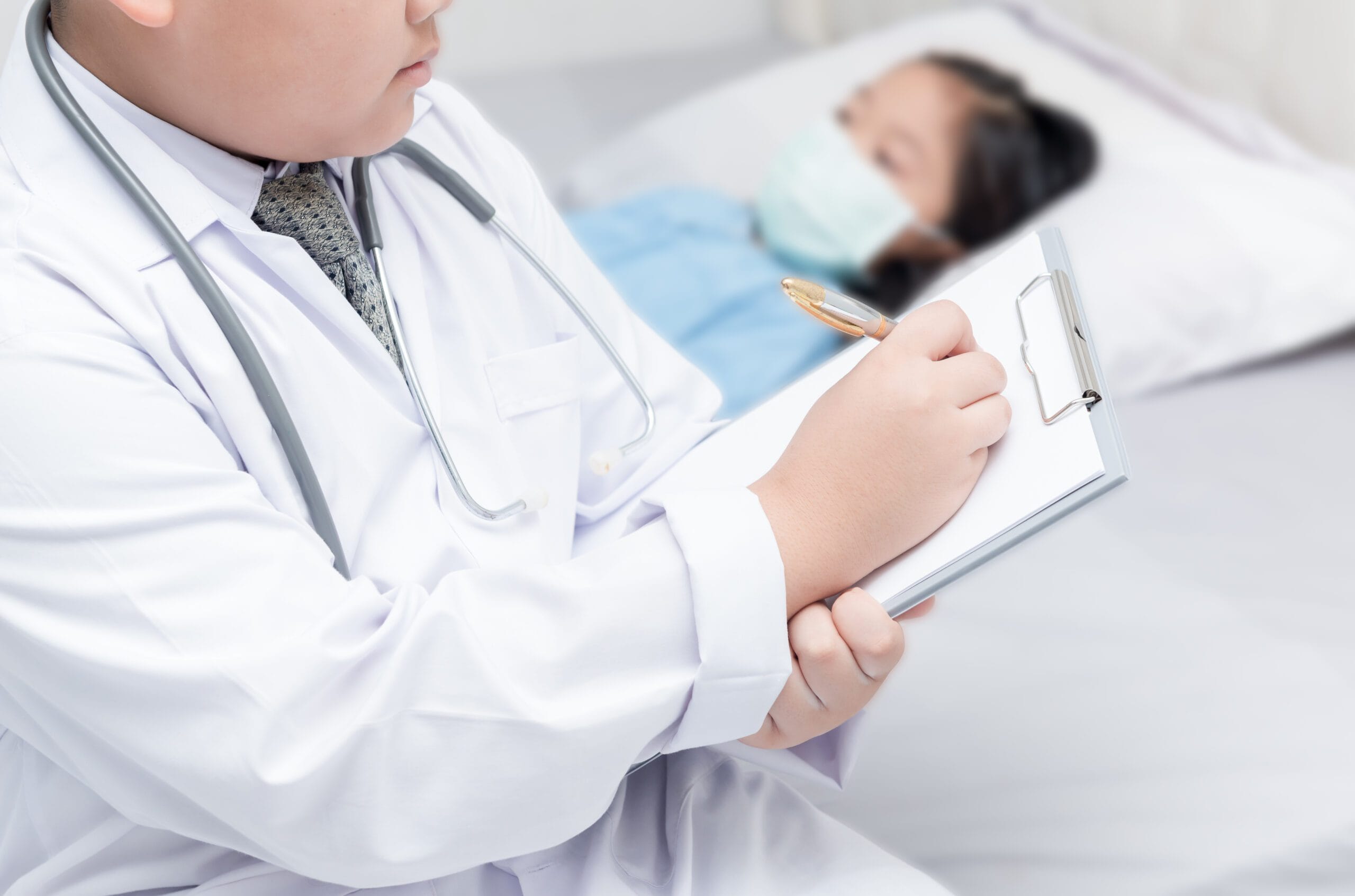 A pediatric endocrinologist reviewing medical records with a coding specialist.