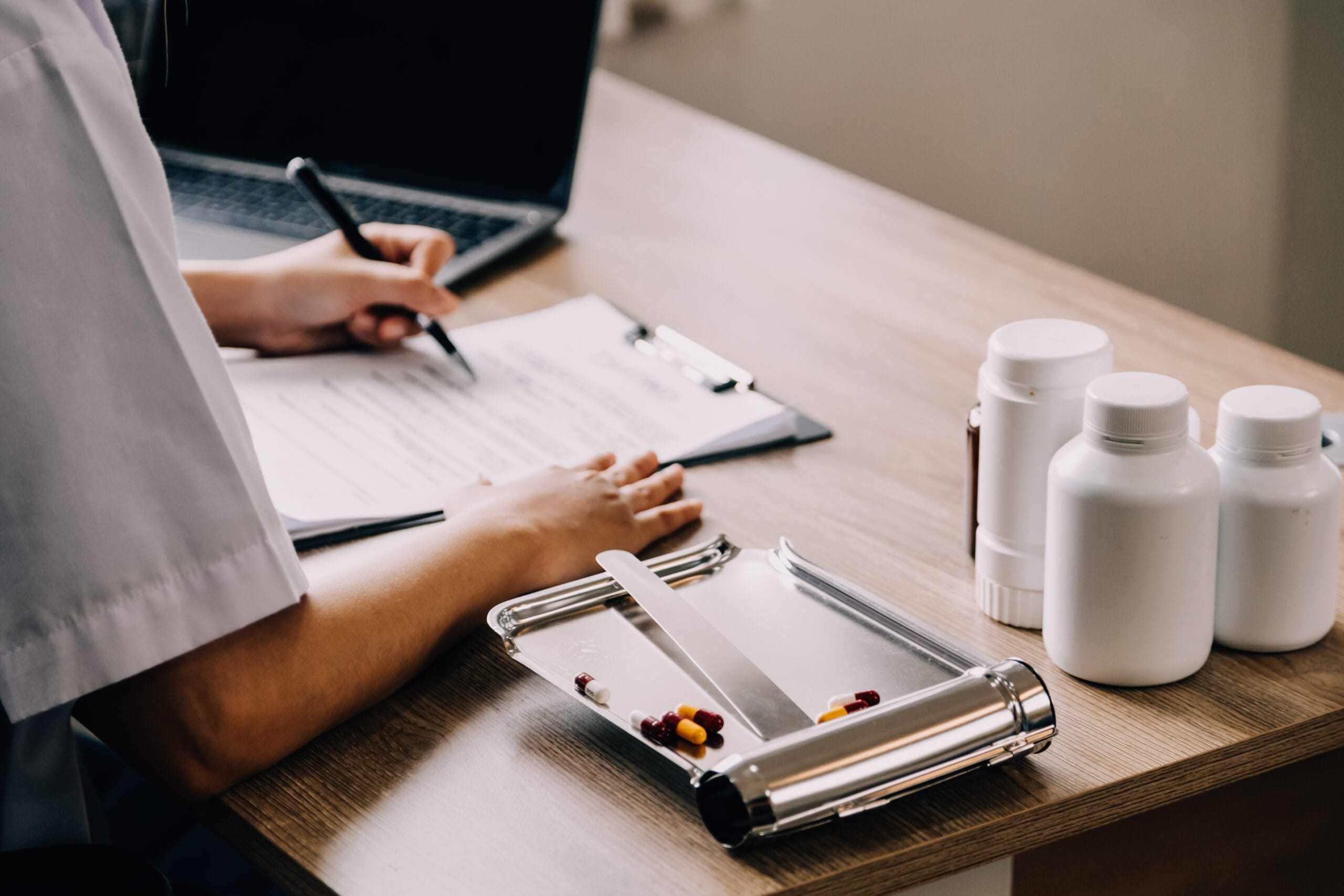 A healthcare administrator reviewing insurance verification documents in a hospital office.