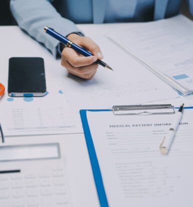 A medical coder reviewing patient records to ensure accurate and timely healthcare reimbursement.