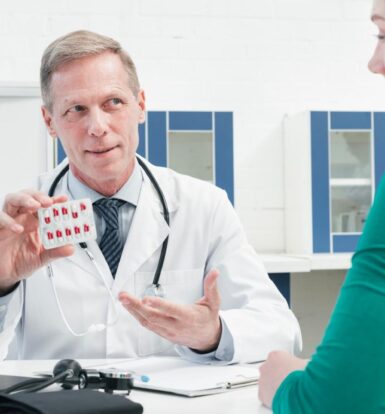 Doctor explaining medication and prior authorization requirements to a patient in a clinical setting.