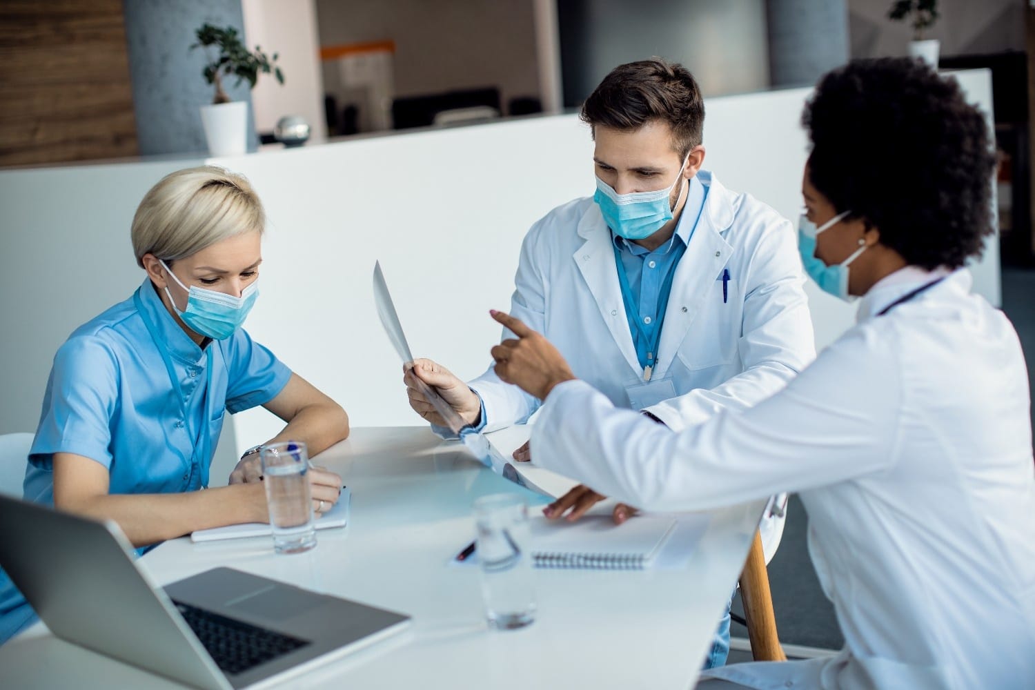 Healthcare team discussing insurance verification and administrative tasks in a hospital setting.