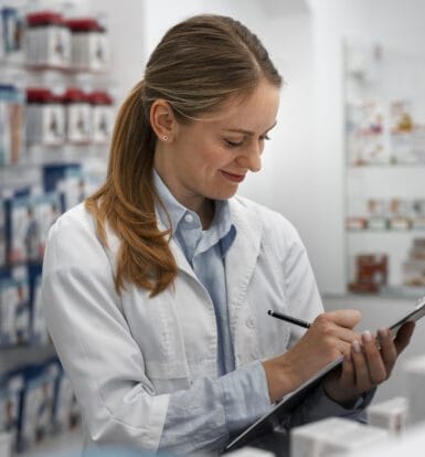 A pharmacist reviewing a clipboard in a pharmacy, representing efficient compliance management through outsourcing services.