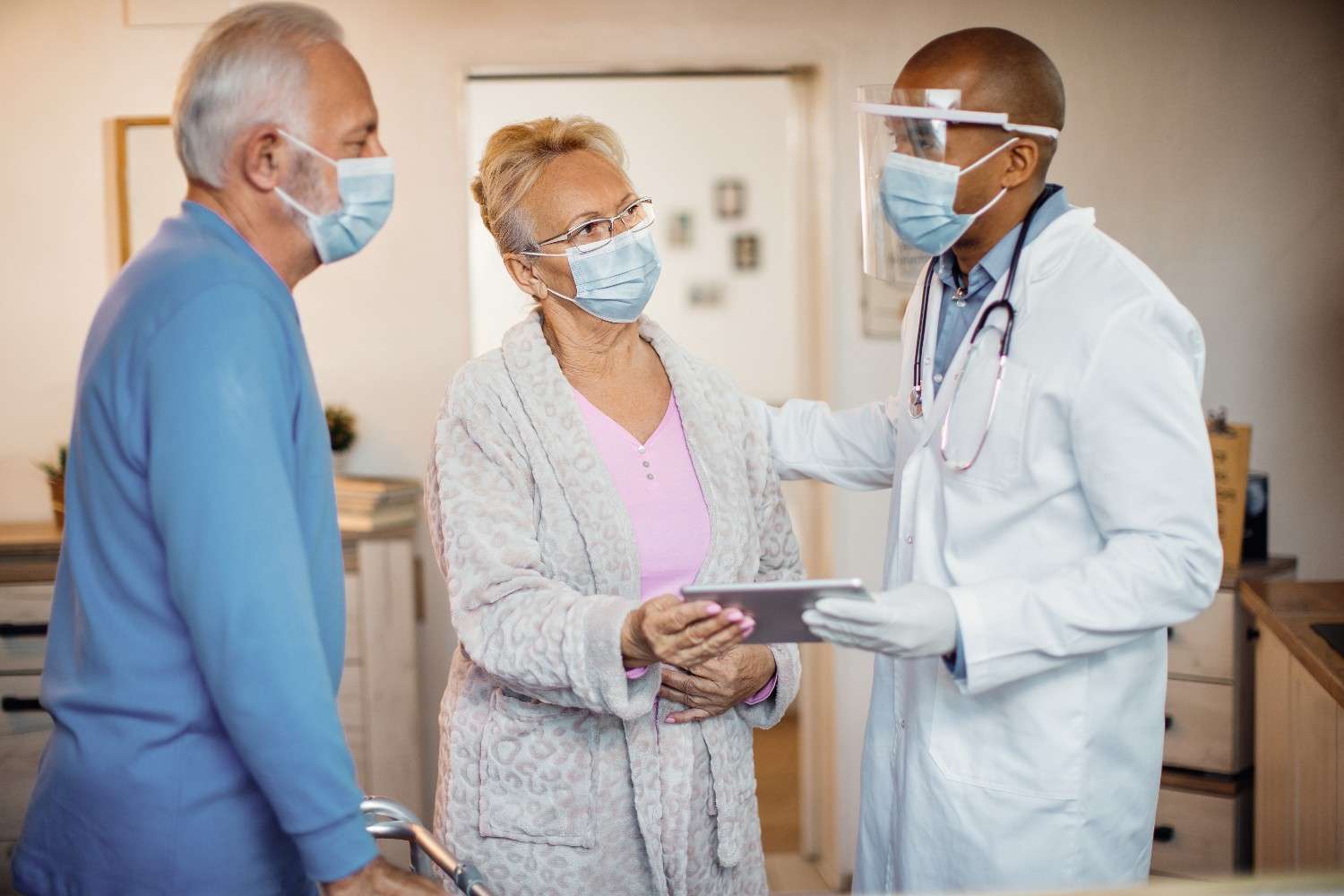 A doctor discussing a prior authorization process with elderly patients, focusing on medication approval and healthcare planning.