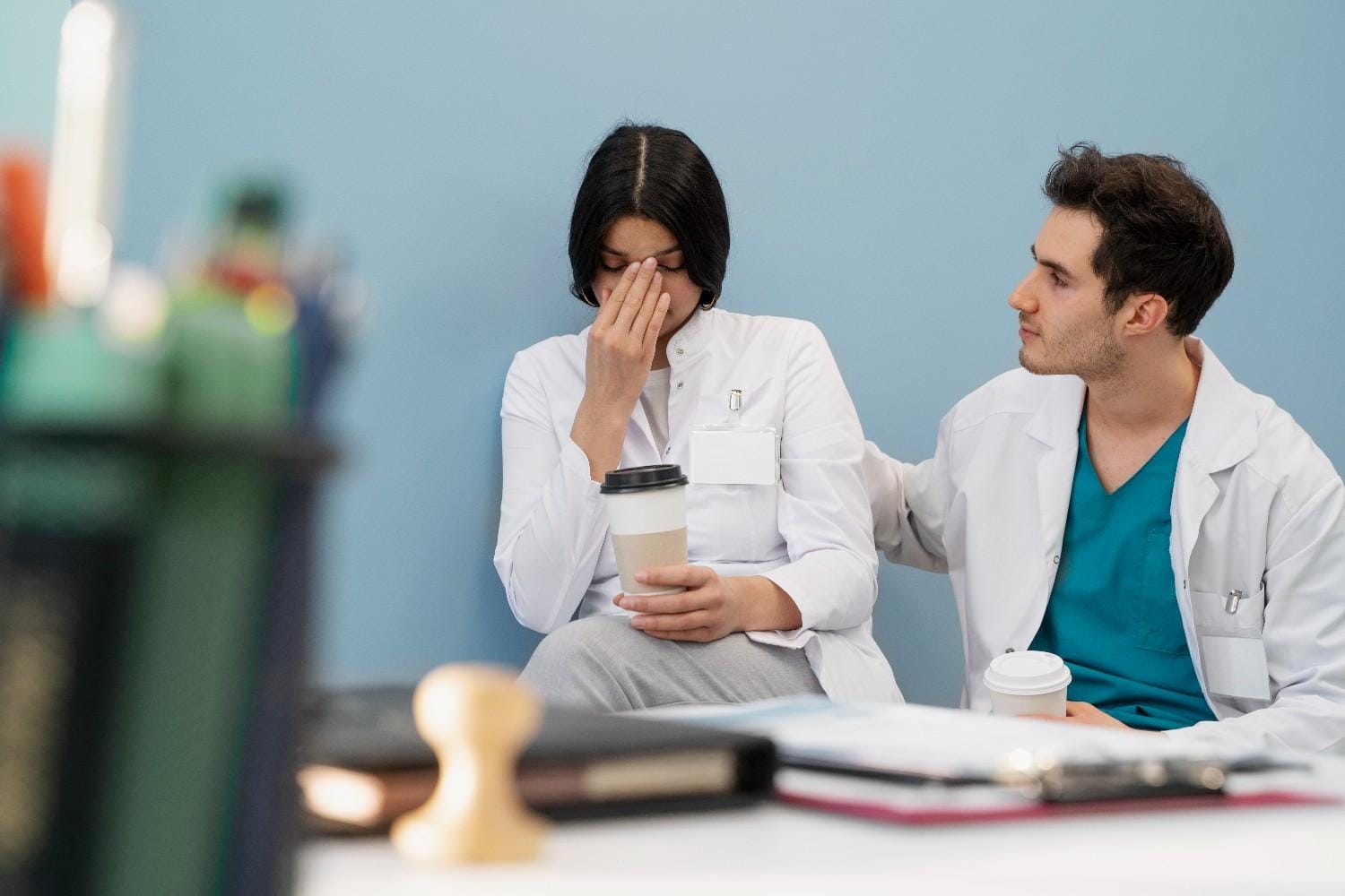 A concerned doctor comforting a distressed colleague, symbolizing the challenges of managing prior authorization denials for Clozapine.