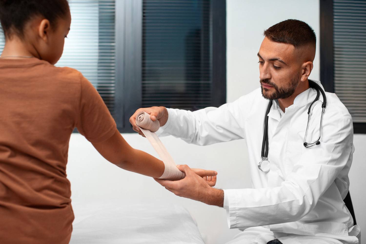 Doctor bandaging child's arm during a medical consultation