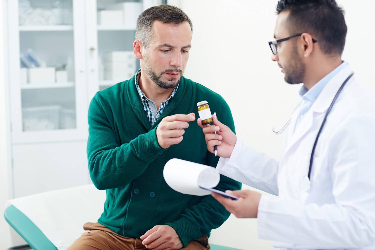 A doctor explaining medication requirements to a patient, helping him understand the process for prior authorization under Medicare for a prescribed medication.