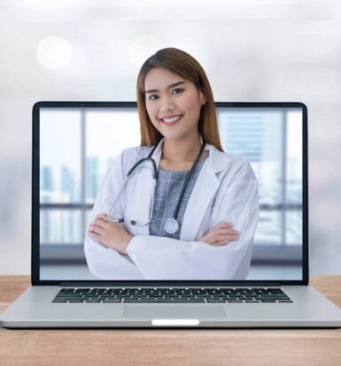 A smiling virtual healthcare assistant in a white coat displayed on a laptop screen, representing remote medical support for practices.