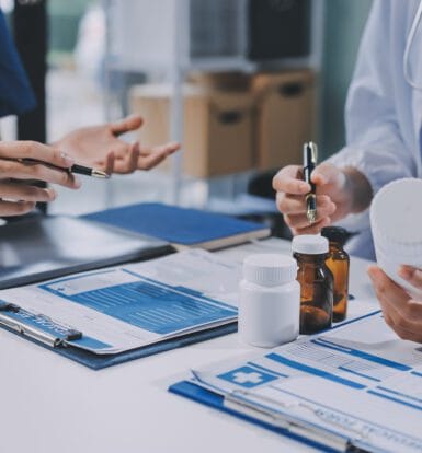 Healthcare professional discussing outsourcing benefits with a doctor.