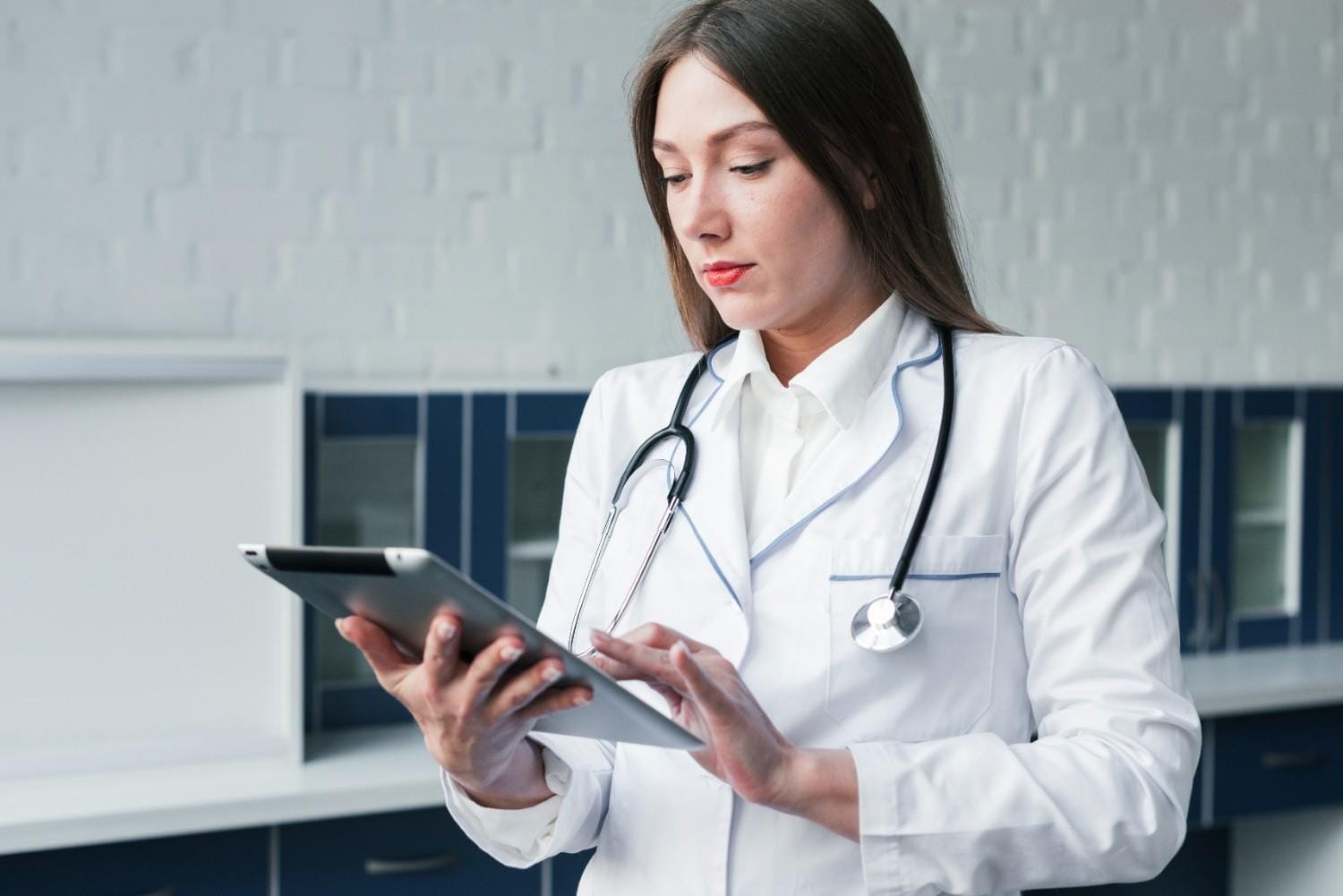 A healthcare provider using a tablet to manage patient data, representing the efficiency of outsourcing Virtual Assistants for practice management.