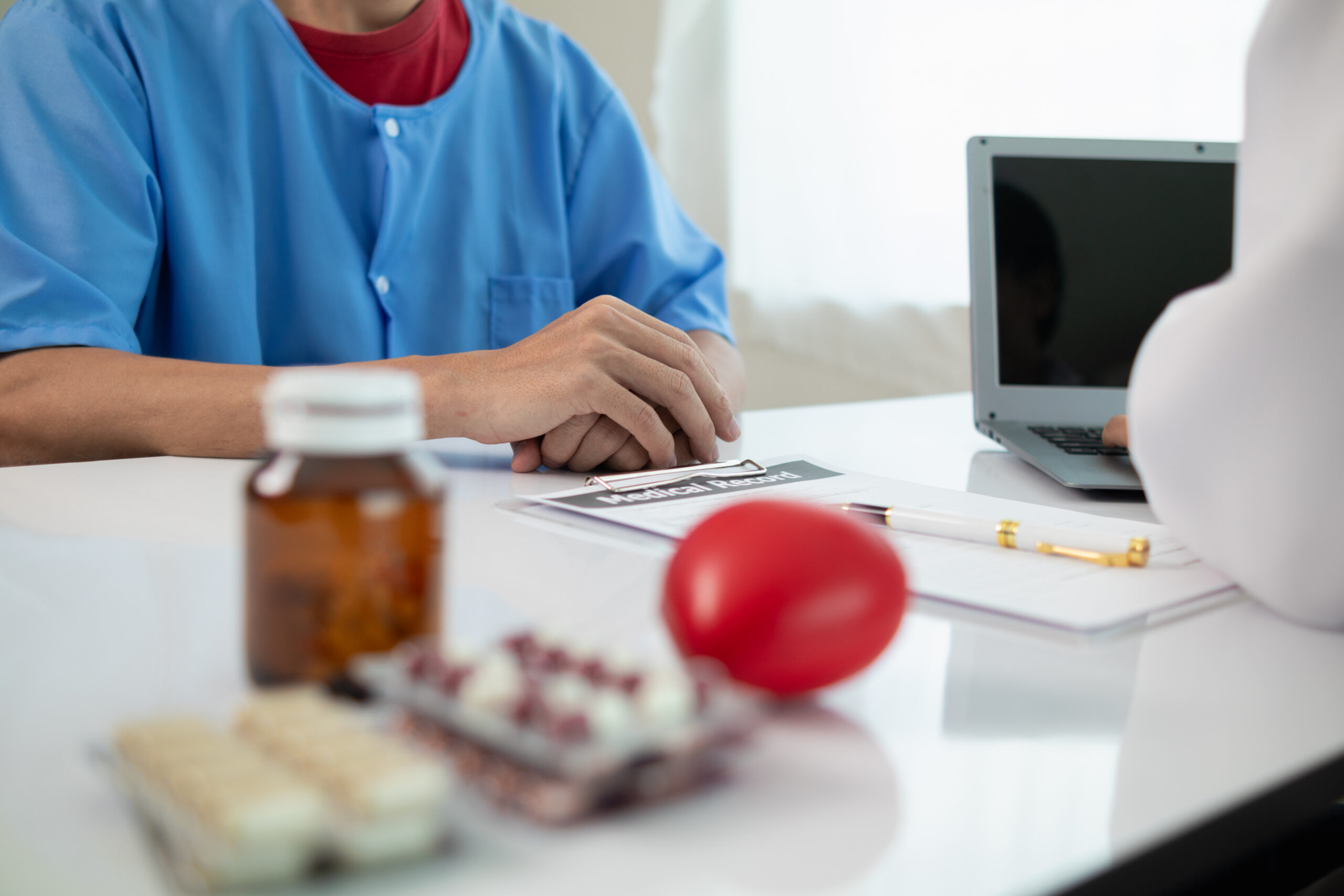 A stressed healthcare worker handling prior authorization paperwork.