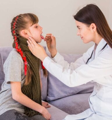 Pediatric doctor performing a medical check-up on a young girl with growth hormone deficiency.