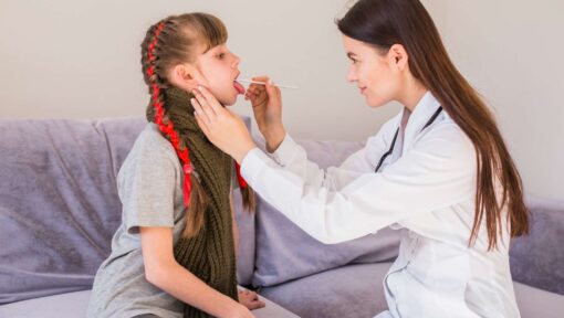 Pediatric doctor performing a medical check-up on a young girl with growth hormone deficiency.