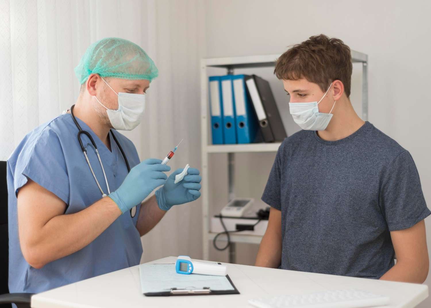 A healthcare professional in scrubs and a mask preparing an injection while consulting with a patient wearing a mask, highlighting a prior authorization process in healthcare.