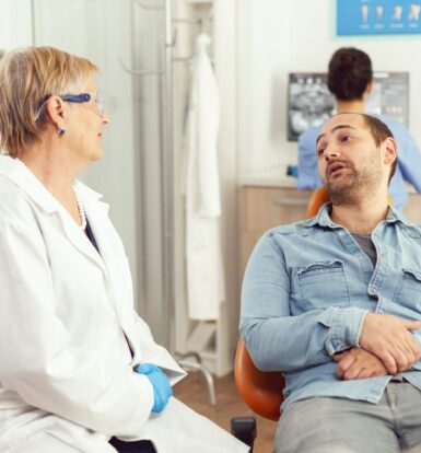 A doctor discussing treatment options and prior authorization for Epclusa with a patient in a clinic setting.