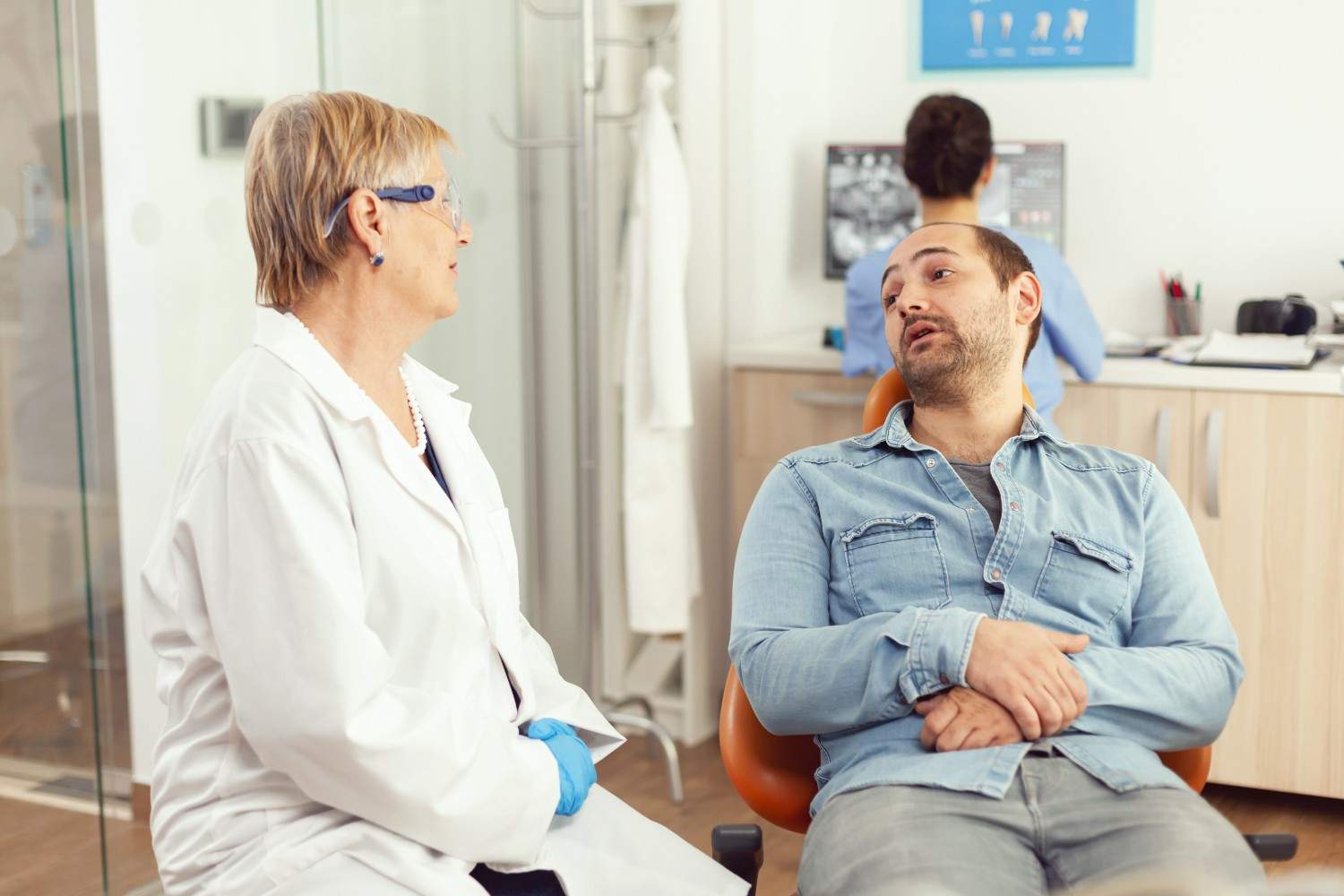 A doctor discussing treatment options and prior authorization for Epclusa with a patient in a clinic setting.