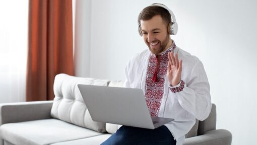 A smiling virtual assistant in headphones engaging in an online meeting, showcasing modern remote healthcare support.