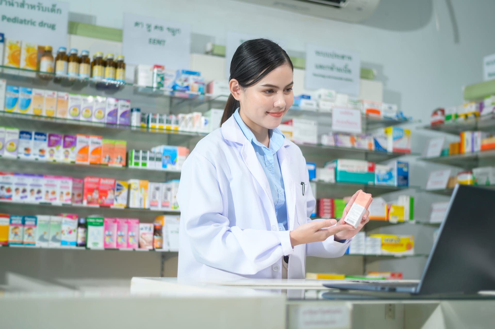 Pharmacy technician using an automated billing system.