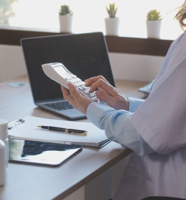 A medical scribe documenting patient information alongside a physician in a clinical setting.