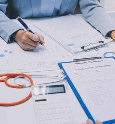 A medical coder working on patient documentation and codes in a healthcare setting.