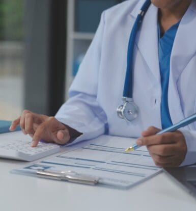 A hospital medical coder reviewing diagnosis-related group codes on a computer screen.