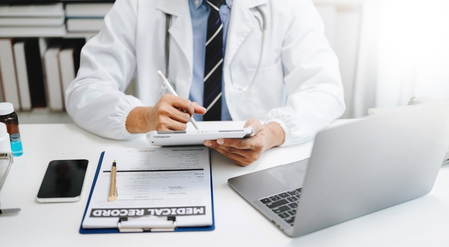 A healthcare provider working with a remote medical scribe on a tablet.