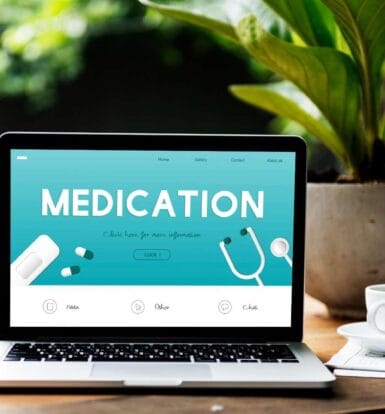 Medication website on a laptop screen, showcasing healthcare services with a stethoscope and pills in the design.