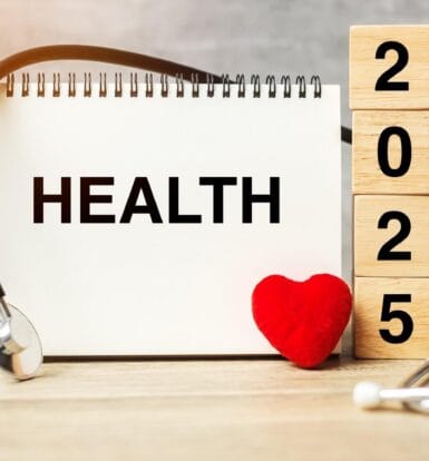 Notebook displaying the word "HEALTH" with a stethoscope, heart, and wooden blocks reading "2025," symbolizing advancements in healthcare.